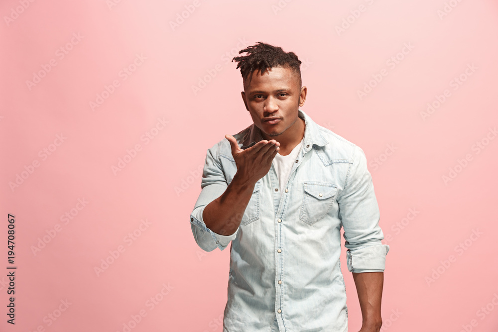 Portrait of attractive Afro-American man with air kiss isolated over pink background Portrait of attractive Afro-American man with air kiss isolated over pink background