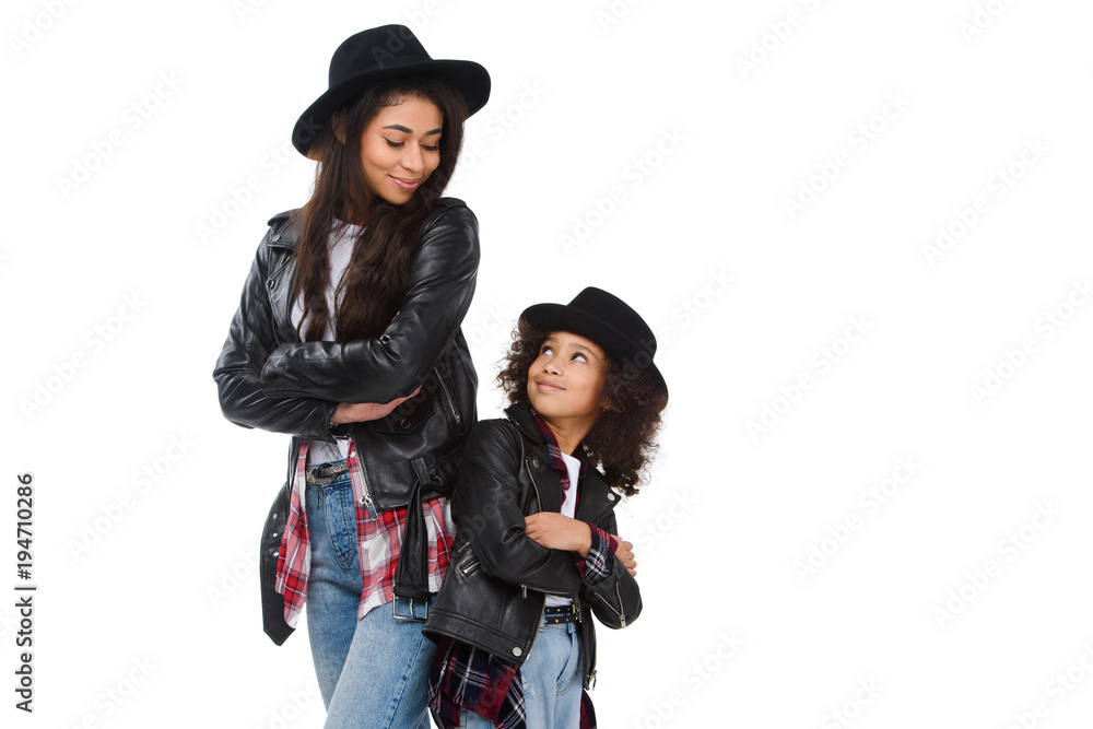 stylish mother and daughter in similar clothes standing back to back isolated on white stylish mother and daughter in similar clothes standing back to back isolated on white