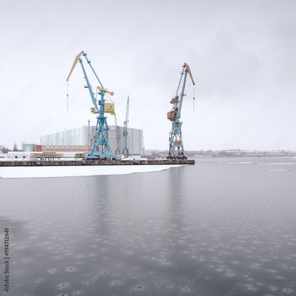 cranes at dock against sky