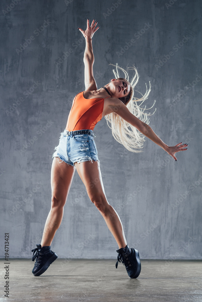 Young beautiful female dancer is posing in the studio