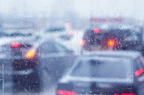 Fototapeta Naklejka Na Ścianę i Meble -  Rain drops on the windshield of the car. View of the traffic jam.