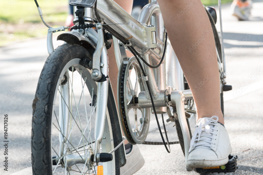 Close up young woman riding bike bicycle in the natural public park Close up young woman riding bike bicycle in the natural public park