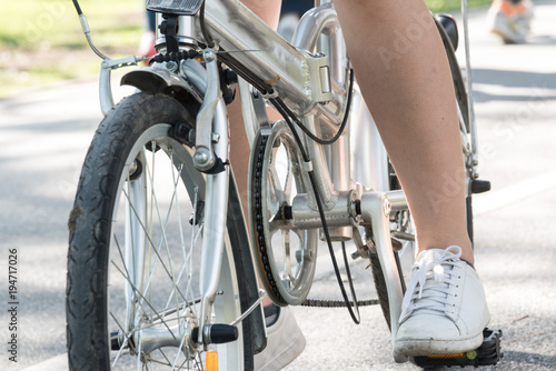 Close up young woman riding bike bicycle in the natural public park