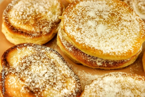 Fritters with powdered sugar on the beige dish