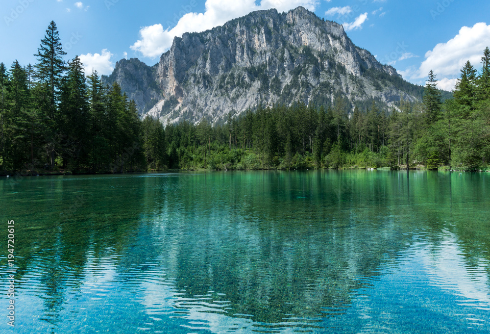 Picture perfect alpine lake reflecting an imposing mountain in the background on a sunny, summer day