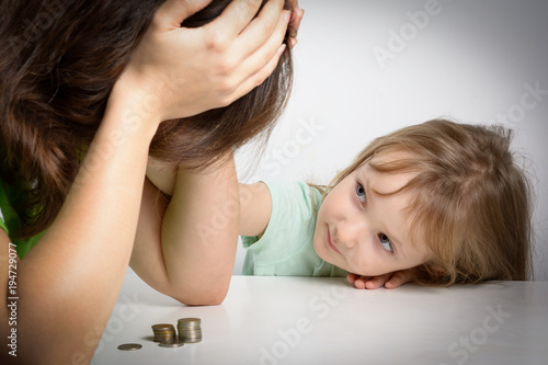Small family. Single mother has financial problems. Her little daughter calms down sad mother.