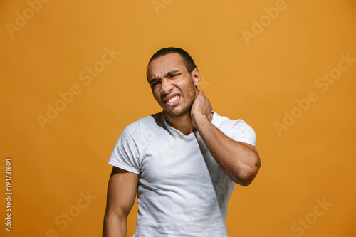 Young man overwhelmed with a pain in the neck