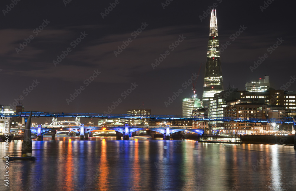 Beautiful landscape image of the London skyline at night looking along the River Thames Beautiful landscape image of the London skyline at night looking along the River Thames