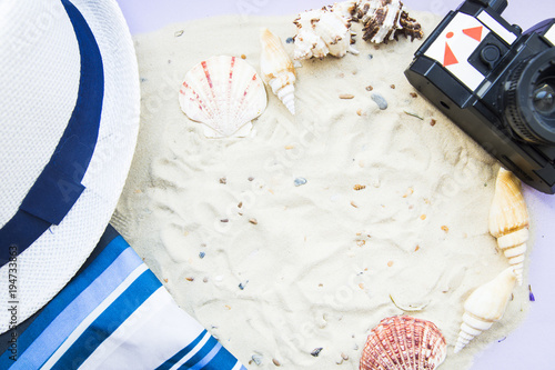 Vacation concept. White tropical sand seashells, old vintage roll camera, a hat, top view, flat lay photo