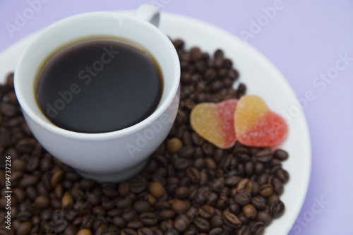 Coffee with sweets on light purple background
