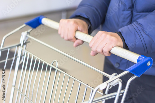 Man and shop trolley. Concept of shopping in supermarket