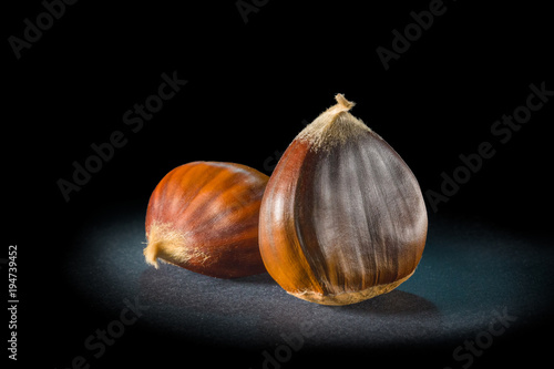 Still life of some chestnuts on a black background.