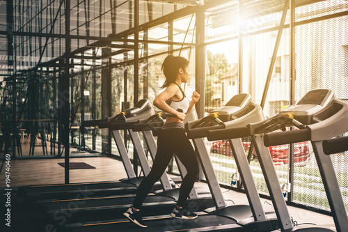 Woman running on treadmill at gym