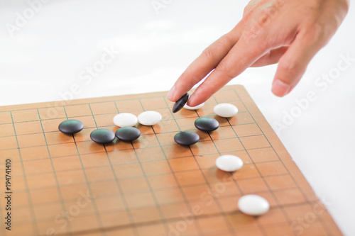 Game's white and black stone on cross board.
