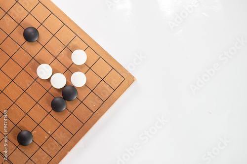 Game's white and black stone on cross board.