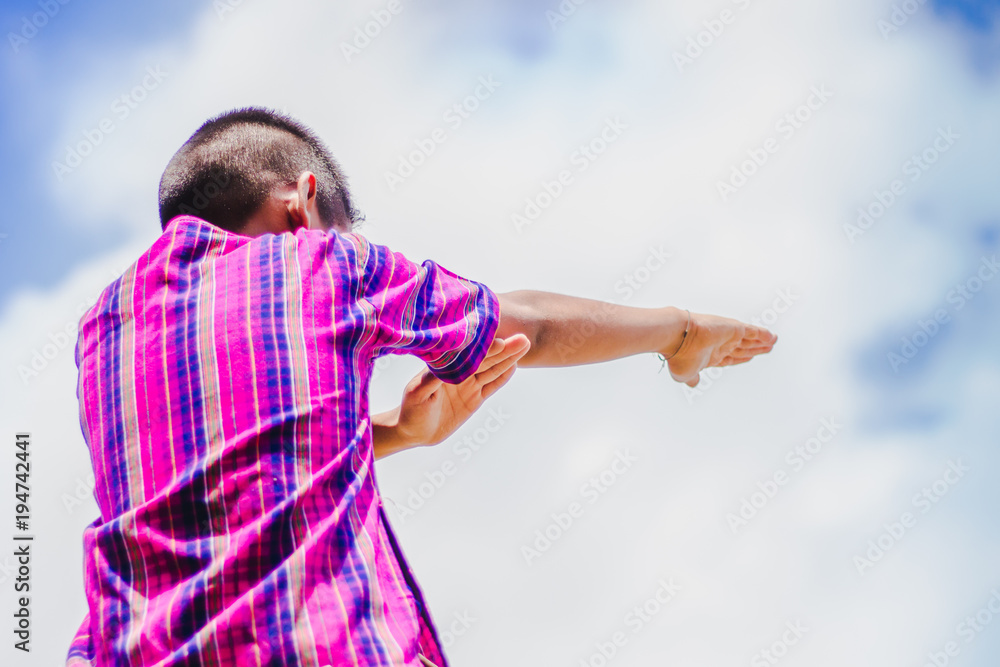 Naklejka premium Student acting like a superhero on top of stepladder in school.