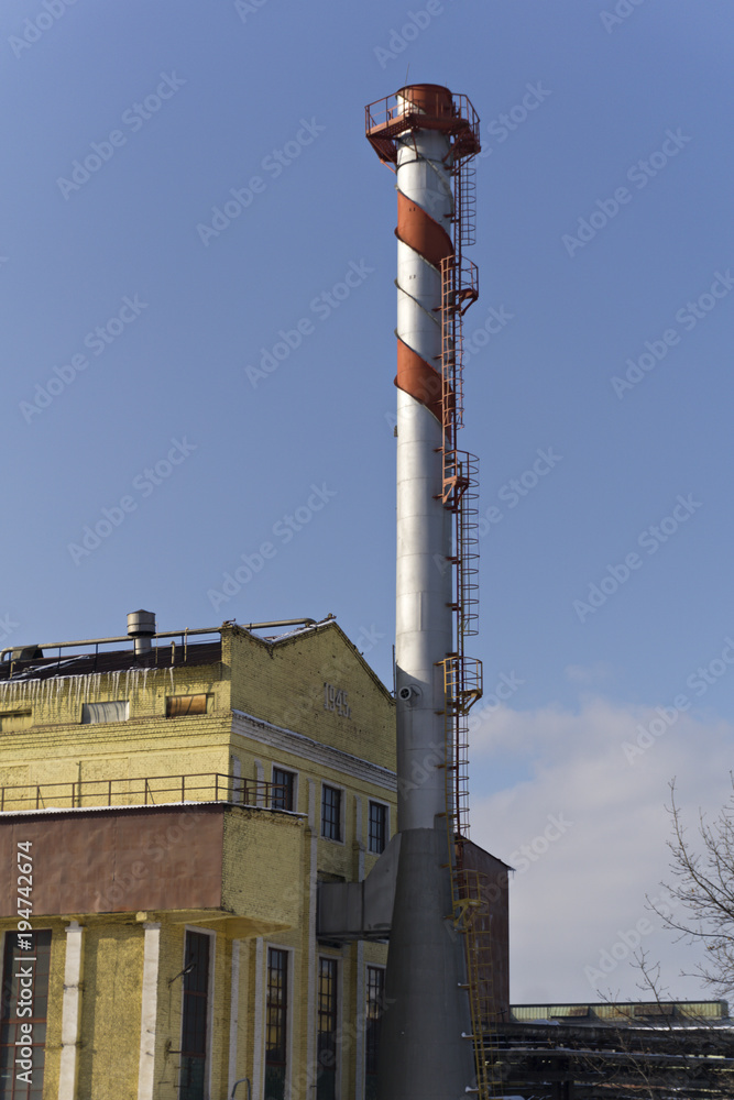 industrial steel spiral chimney near the old factory building