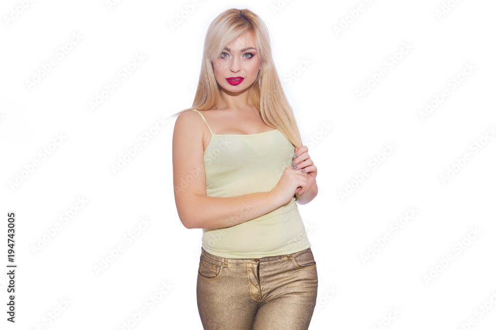 Studio portrait of a beautiful young blond woman with long hair, dressed in a summer yellow jersey and golden jeans. Concept: summer mood. Isolate. Copy space Studio portrait of a beautiful young blond woman with long hair, dressed in a summer yellow jersey and golden jeans. Concept: summer mood. Isolate. Copy space