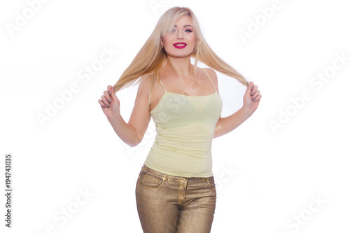 Studio portrait of a beautiful young blond woman with long hair, dressed in a summer yellow jersey and golden jeans. Concept: summer mood. Isolate. Copy space © yevgeniya131988