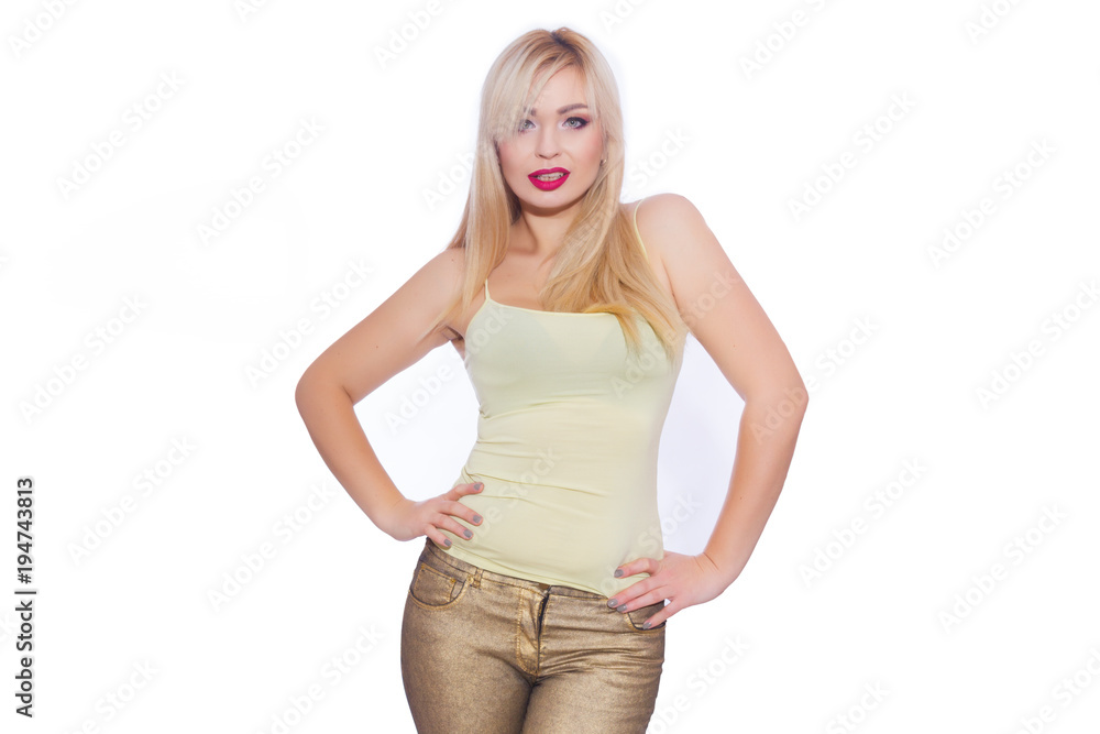 Studio portrait of a beautiful young blond woman with long hair, dressed in a summer yellow jersey and golden jeans. Concept: summer mood. Isolate. Copy space Studio portrait of a beautiful young blond woman with long hair, dressed in a summer yellow jersey and golden jeans. Concept: summer mood. Isolate. Copy space