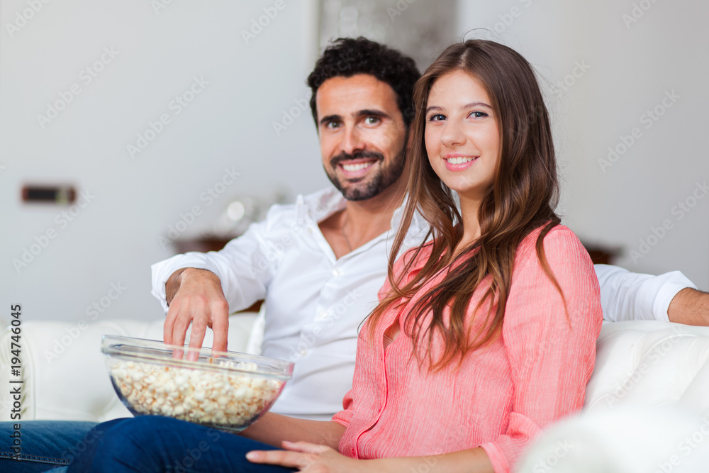 Couple eating popcorn on a couch