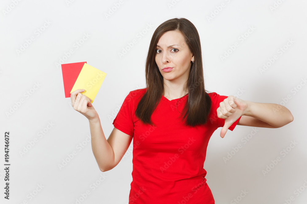 European serious severe young woman, football referee hold choose yellow and red soccer cards, propose player retire from field, show thumb down isolated on white background. Sport, play concept. European serious severe young woman, football referee hold choose yellow and red soccer cards, propose player retire from field, show thumb down isolated on white background. Sport, play concept.