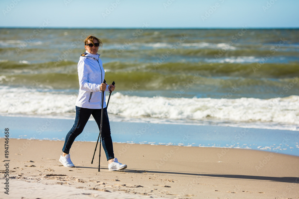 Nordic walking - woman training on beach Nordic walking - woman training on beach