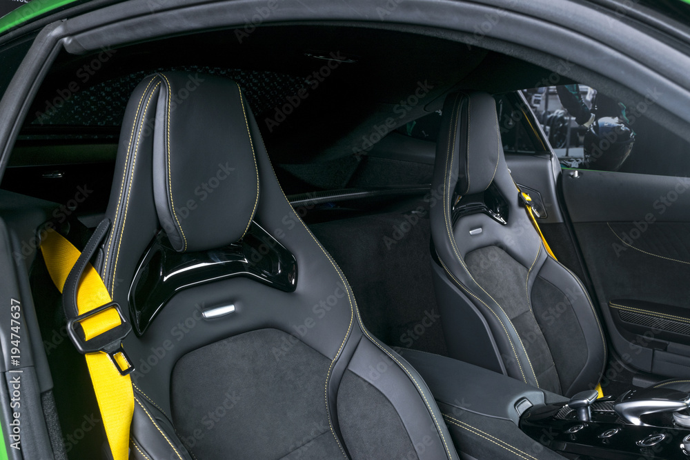 Modern Luxury sport car inside. Interior of prestige car. Black Leather seats with yellow stitching. Black perforated leather. Modern car interior details. Automatic Transmission. Gear lever