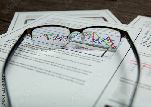 Through the close-up glasses you can see the chart on the financial documents.