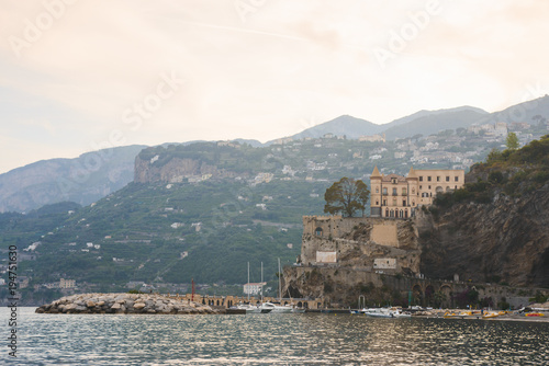 Panoramic aerial view shot of Maiori city with the tiny beach coastline and colorful houses, located on the rock, Amalfi coast, Sorrento, Italy with blue mountains at background