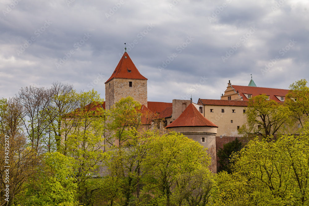Red towers and wall of famous Hradcany castle. Prague, Czech Republic. Gloomy spring weather