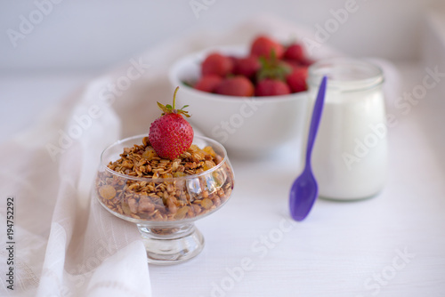 Homemade granola in jar on rustic kitchen table, healthy breakfa photo