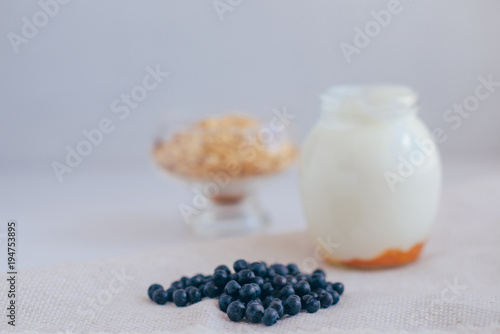 Homemade granola in jar on rustic kitchen table, healthy breakfa photo