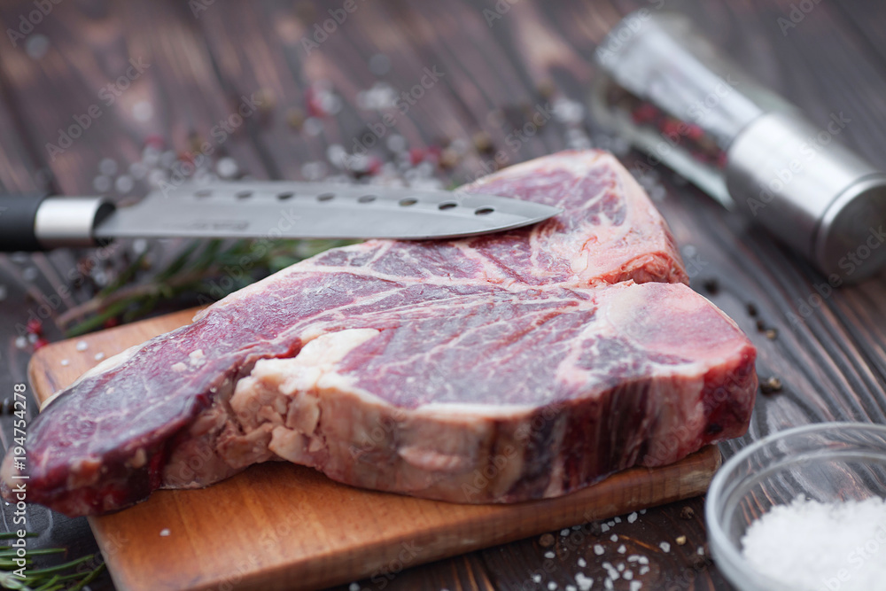 Raw fresh marbled meat Steak and seasonings on dark wooden background