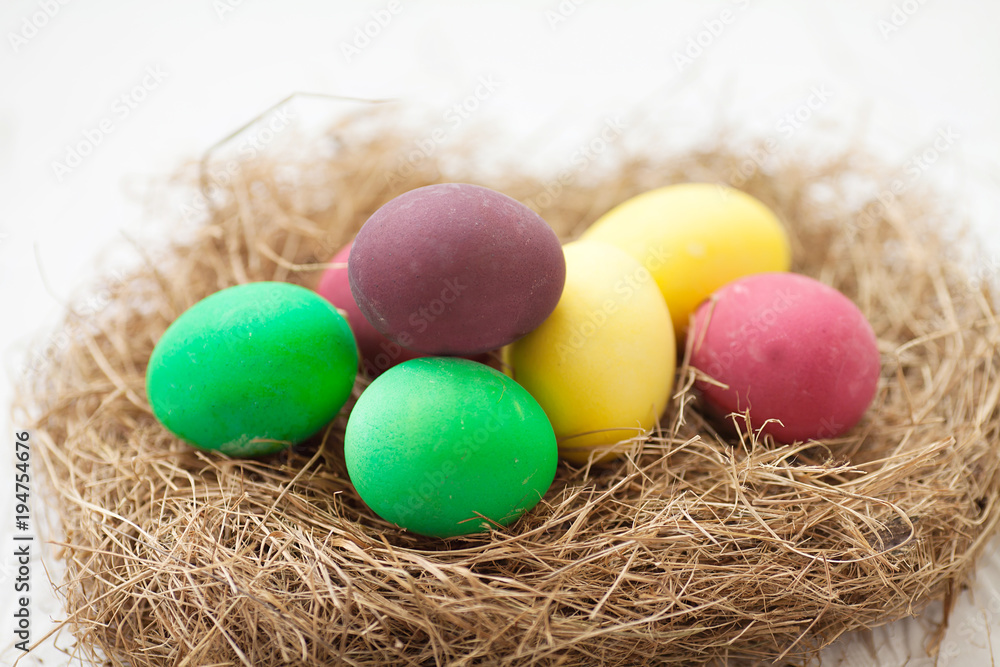 Easter eggs in the nest on white wooden background Easter eggs in the nest on white wooden background