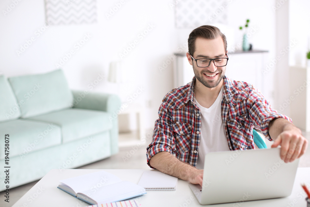 Student with laptop studying at table indoors Student with laptop studying at table indoors