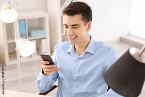 Young man using phone indoors