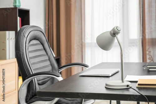 Comfortable workplace with modern lamp on table