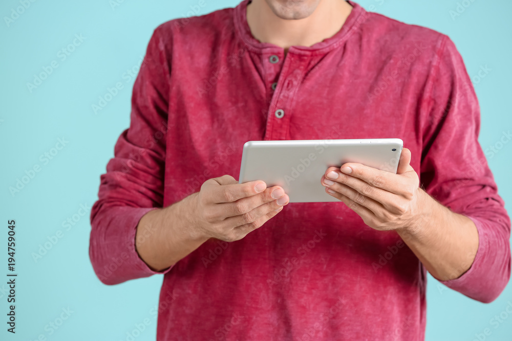 Man using tablet computer on color background Man using tablet computer on color background