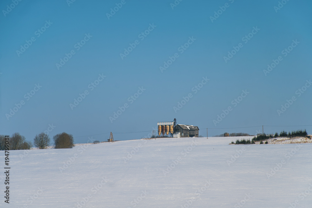 Winter landscape with vintage grain dryer