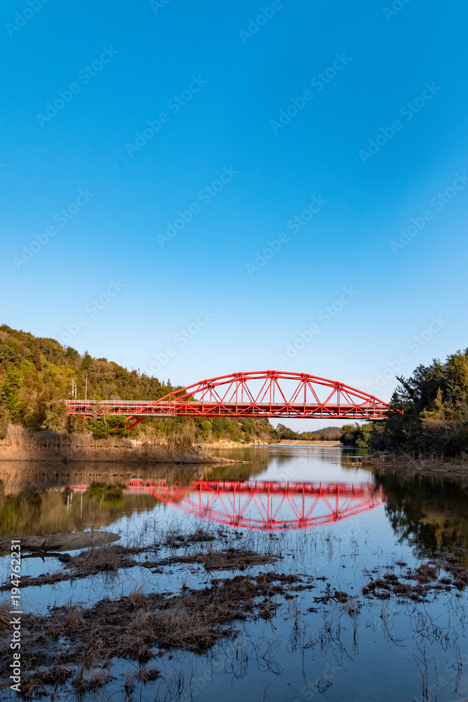 赤い橋、アーチと池の反射、３月の青空、玉野市深山公園にて