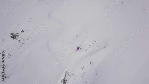 Young man climbing on ski in Alps, aerial footage of winter activity.  photo