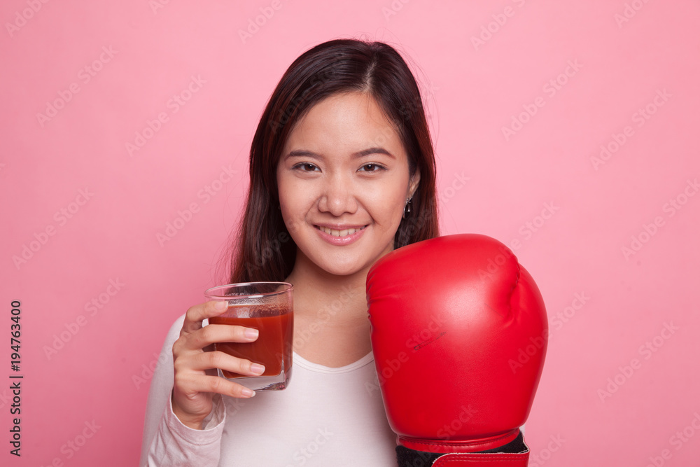 Young Asian woman with tomato juice and boxing glove. Young Asian woman with tomato juice and boxing glove.