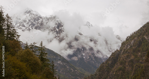 Foggy and cloudy morning mountains in himalayas. Row of mountains with green pine trees.Nepal. nearby Annapurna.