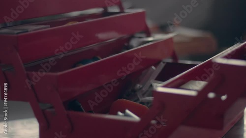 worker in his garage with a red tool storage box preparing for work