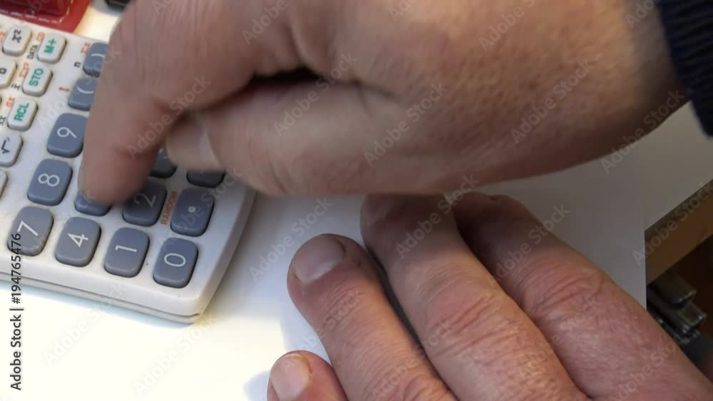 Hands of man performing mathematical calculations with calculator Hands of man performing mathematical calculations with calculator