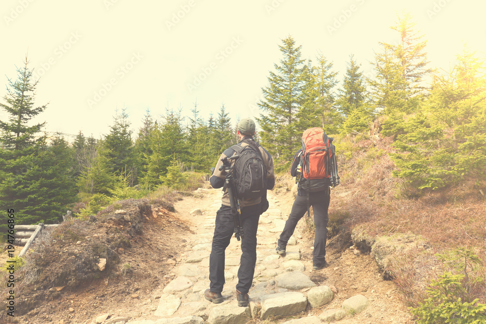 Hiking people with backpacks in mountains