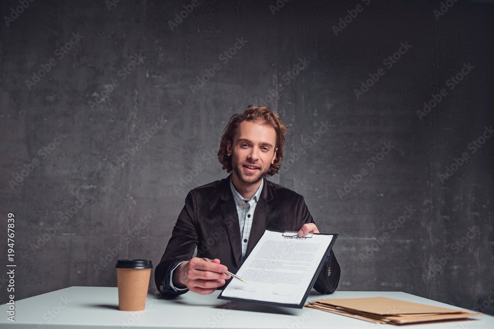 Portrait of happy bearded employer showing contract while sitting at table. Append signature concept Portrait of happy bearded employer showing contract while sitting at table. Append signature concept