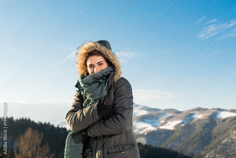 Beautiful girl outdoor in cold snowy winter, looking playful 