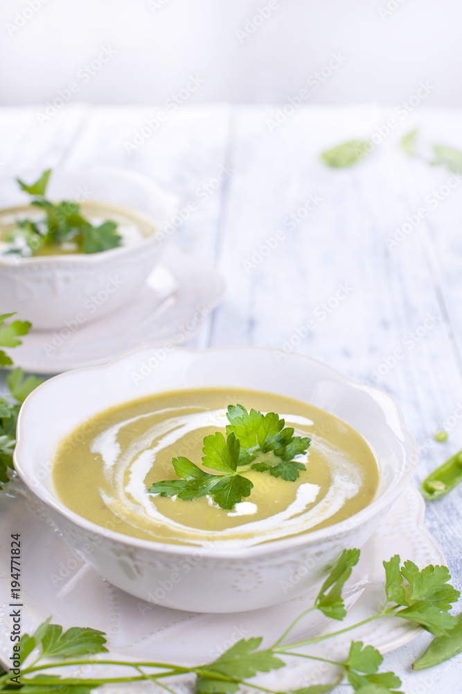 Cream soup with green peas and fresh herbs. Summer dinner. Healthy diet . Soup from vegetables. Free space for text. Vertical photo. Cream soup with green peas and fresh herbs. Summer dinner. Healthy diet . Soup from vegetables. Free space for text. Vertical photo.